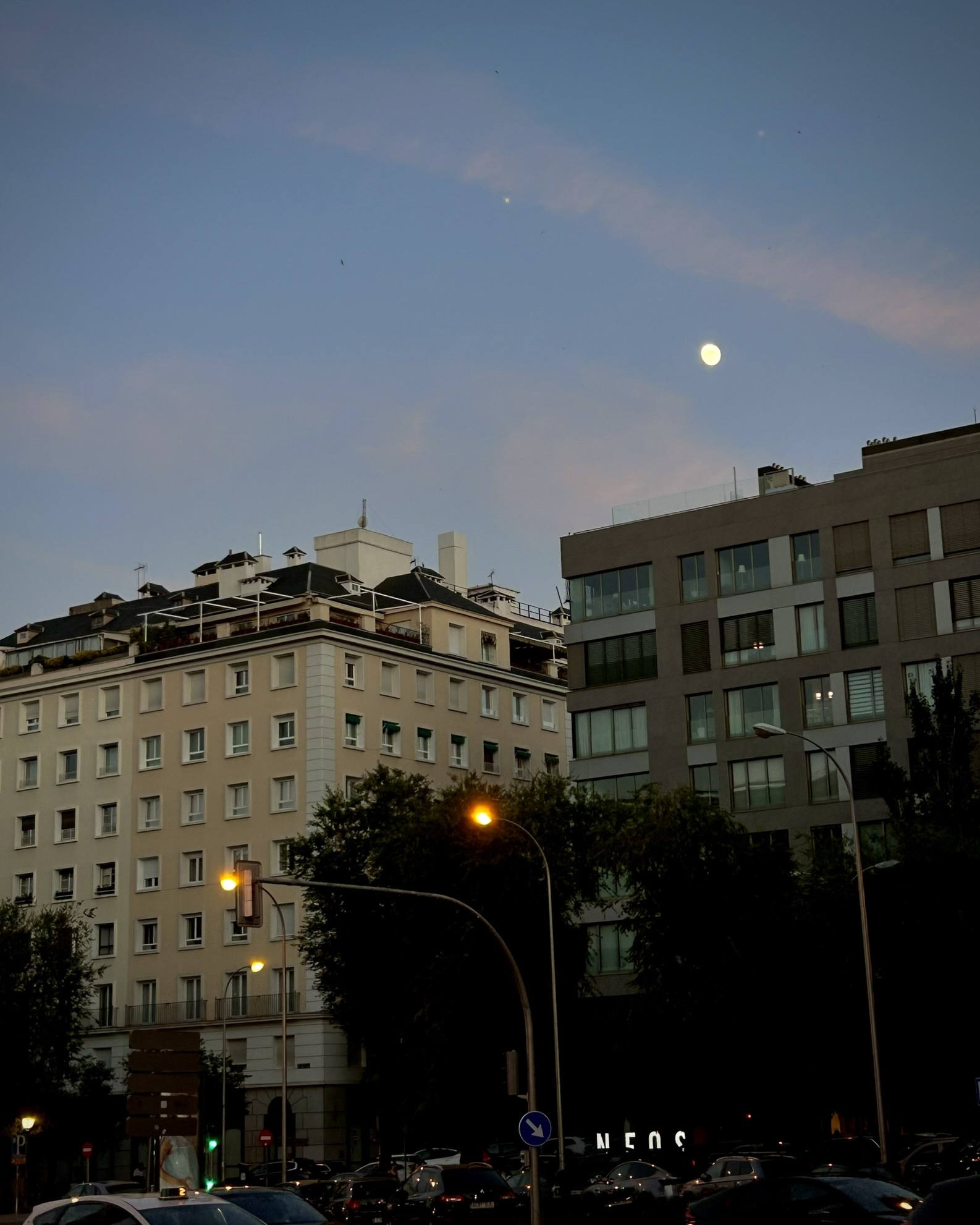Luna sobre edificios de Madrid al anochecer